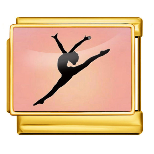 A gold-toned charm with a printed design of a black silhouette of a gymnast or dancer against a soft peach-pink gradient background.