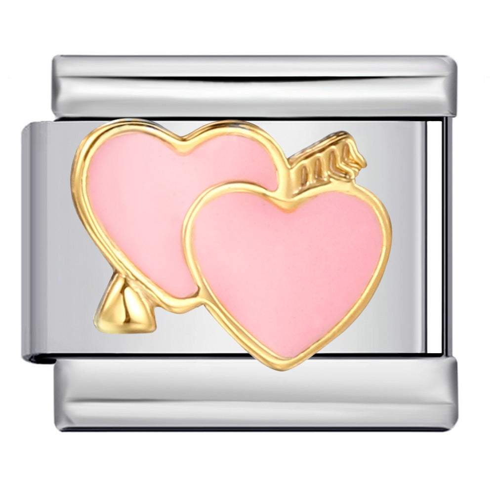 Silver-toned charm link featuring two overlapping pink hearts with a gold outline and a gold arrow through the back of one of the hearts