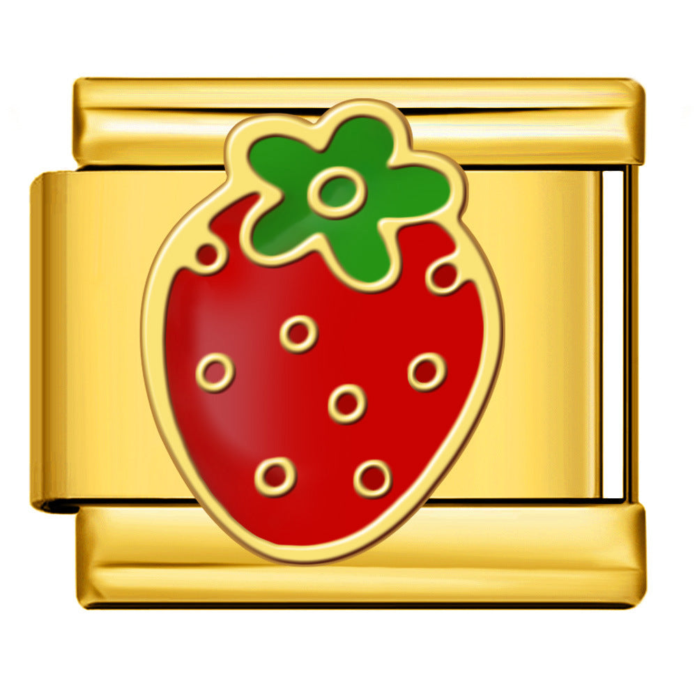 Gold charm with a red strawberry design