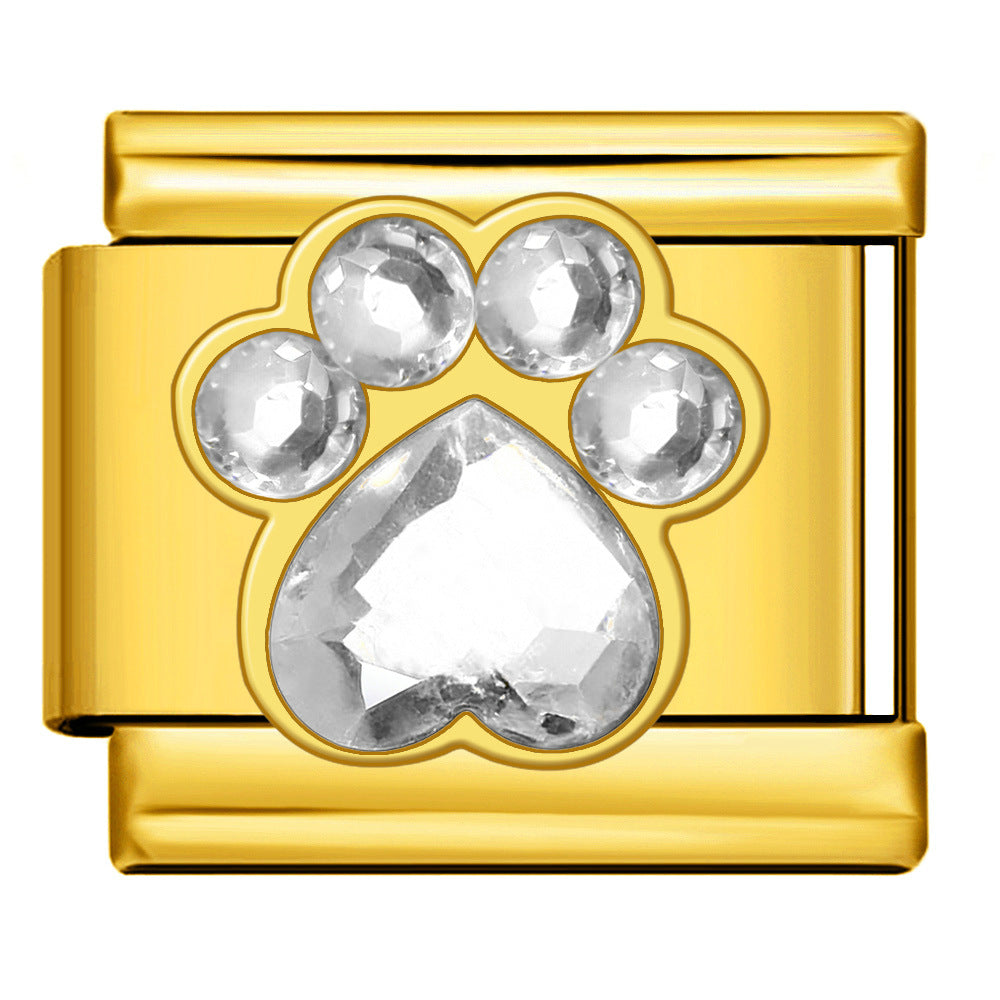 A gold-plated rectangular charm link featuring a paw print design adorned with clear faceted rhinestones