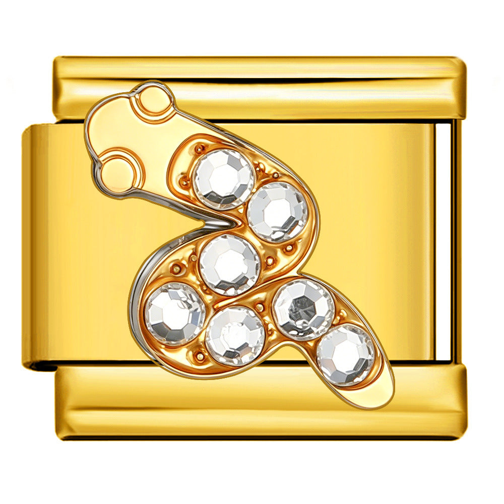 A gold-toned Italian charm link featuring a gold-toned snake design adorned with six clear faceted crystals