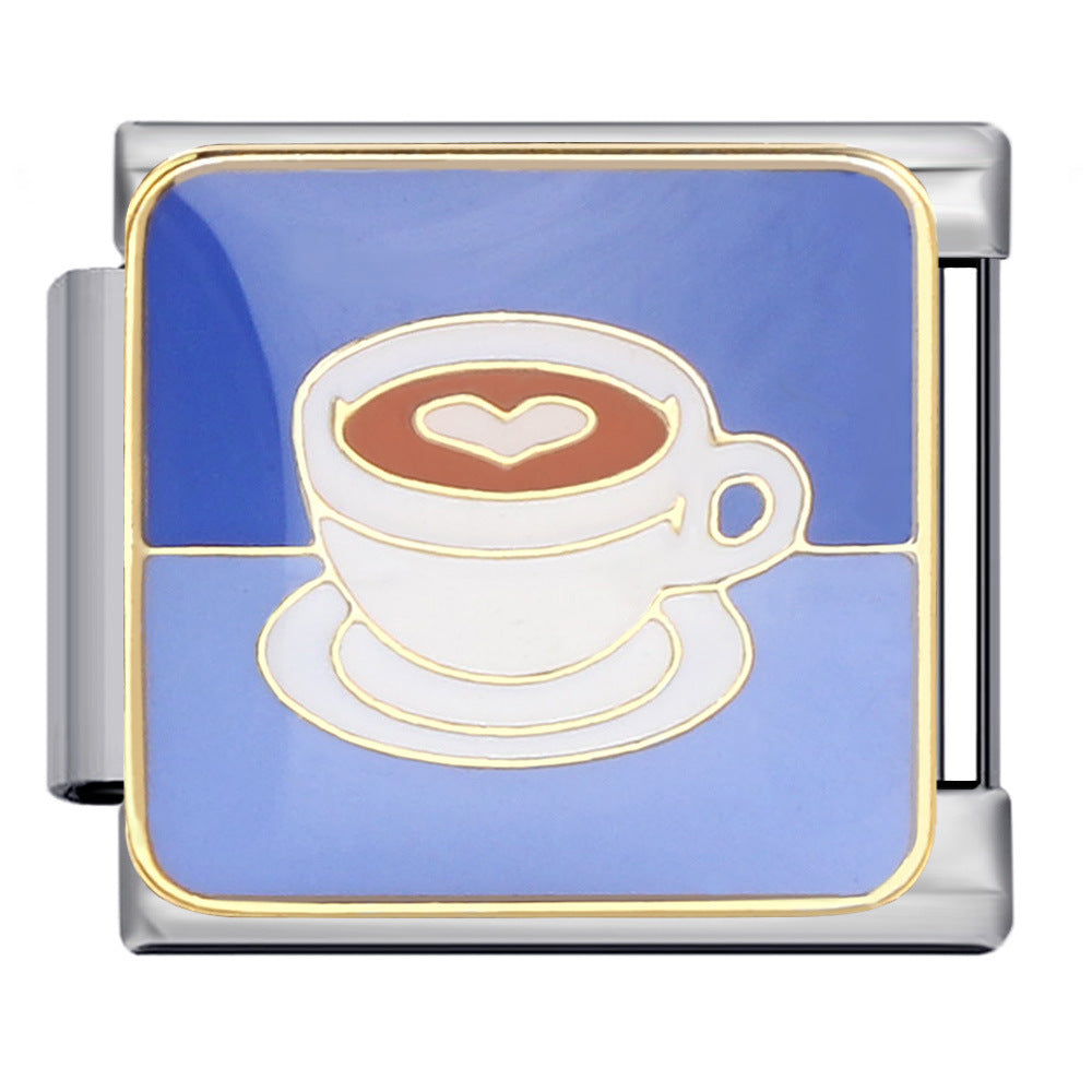 Silver-toned charm link with a white coffee cup with an adorable heart-shaped latte design against a pretty blue background with gold details