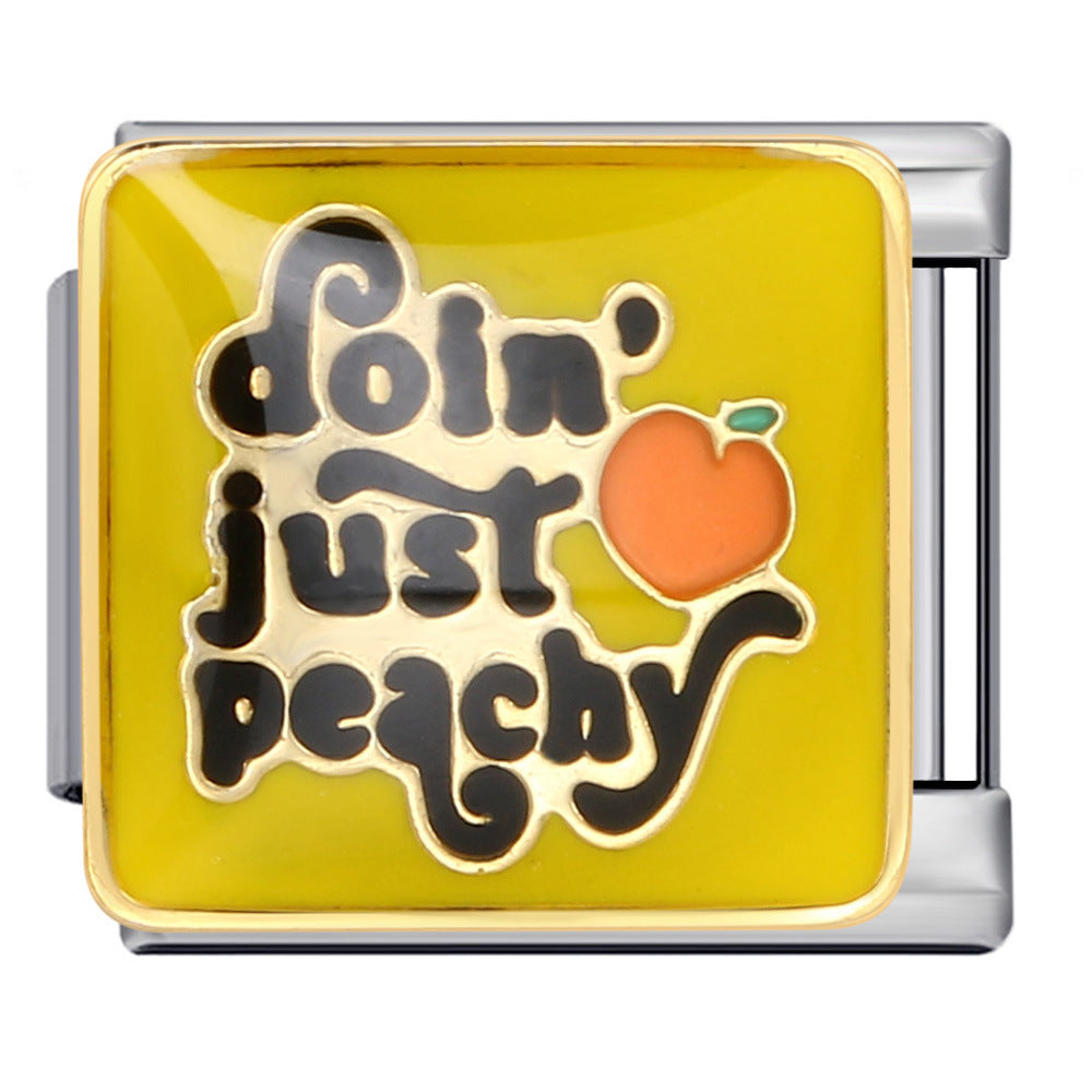 Silver-toned charm link with black letters that say 'doin' just peachy' against a yellow background with an orange peach and green leaf with gold outlines.