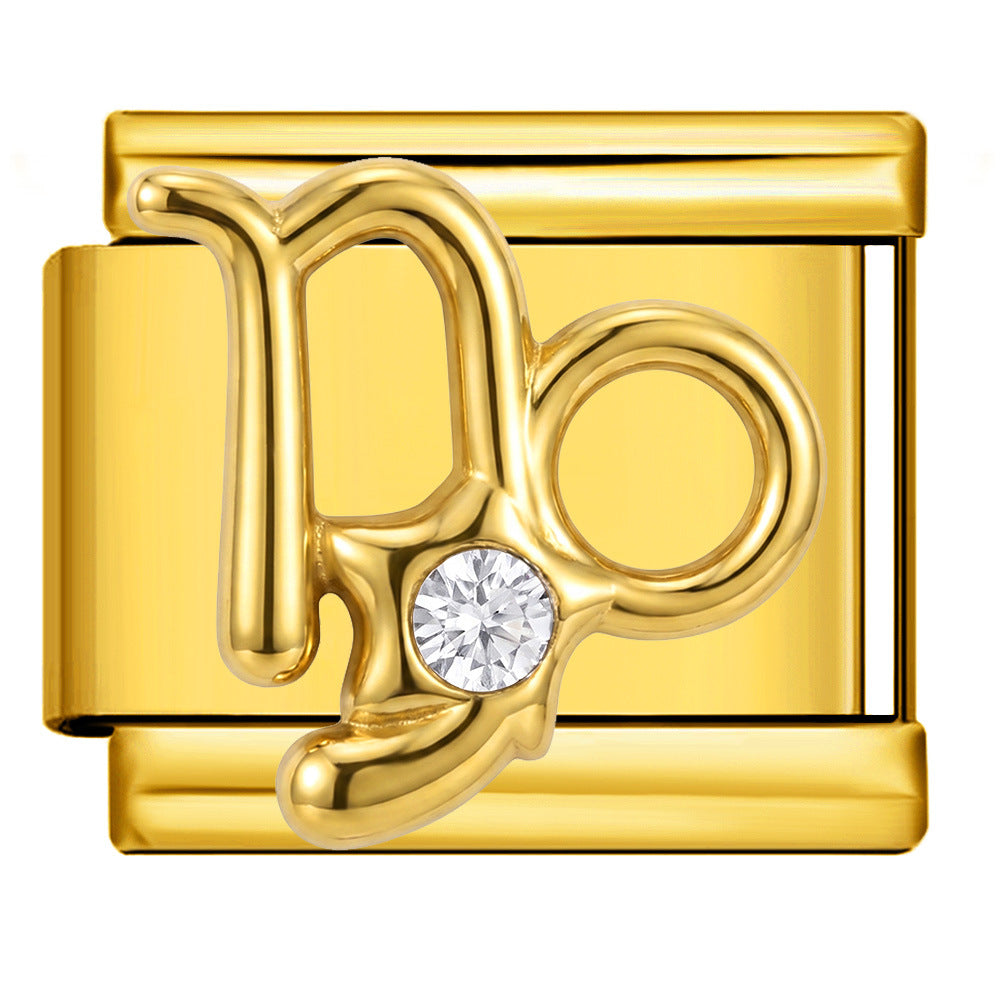 A gold-toned rectangular charm link featuring a stylized Capricorn astrological symbol with a clear round gemstone.