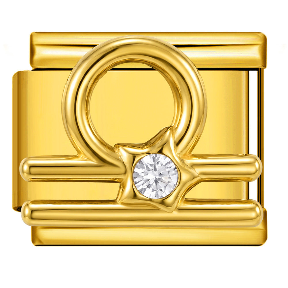 A gold-toned charm link featuring a Libra zodiac sign, a star-shaped element, and a round clear gemstone at the center