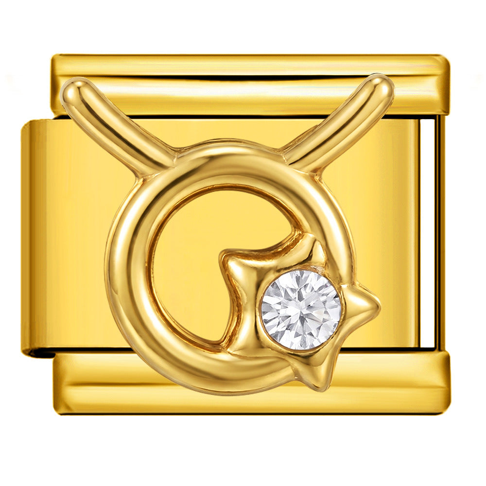 A gold-toned jewelry box with a Taurus zodiac symbol design featuring a clear round gemstone