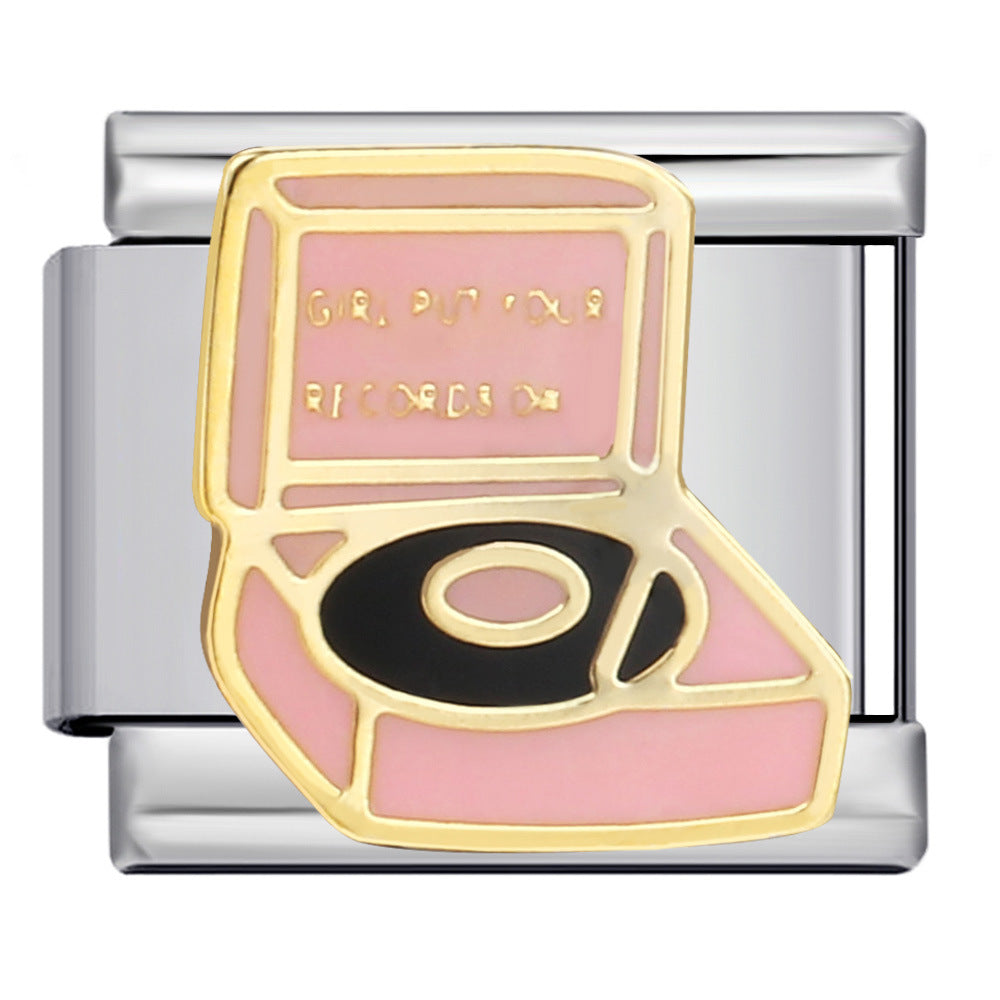 Silver toned charm with a pink record player and gold details with a black vinyl on the player
