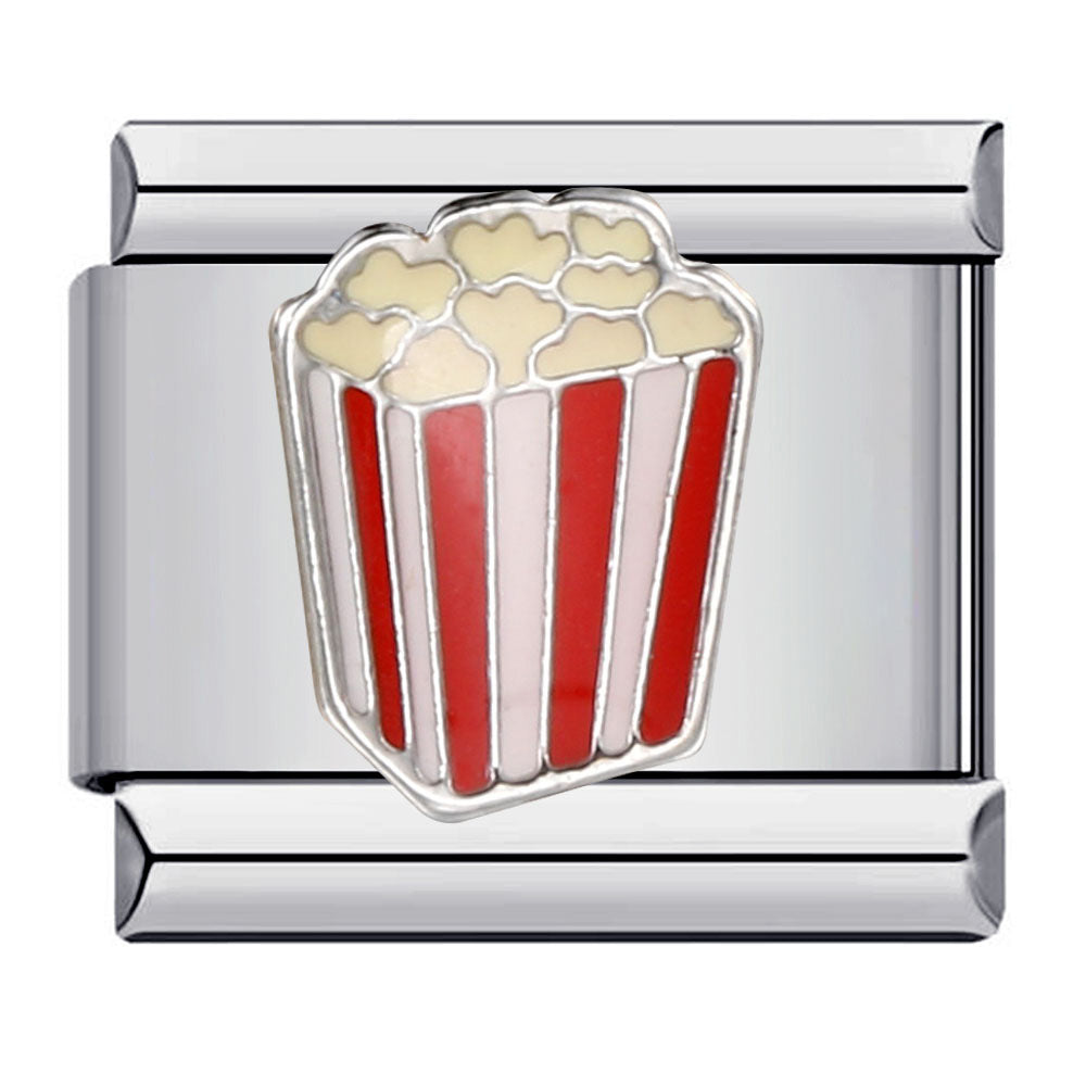 A silver-toned metal charm featuring an enamel popcorn bucket charm with red and white striped sides and beige popcorn on top