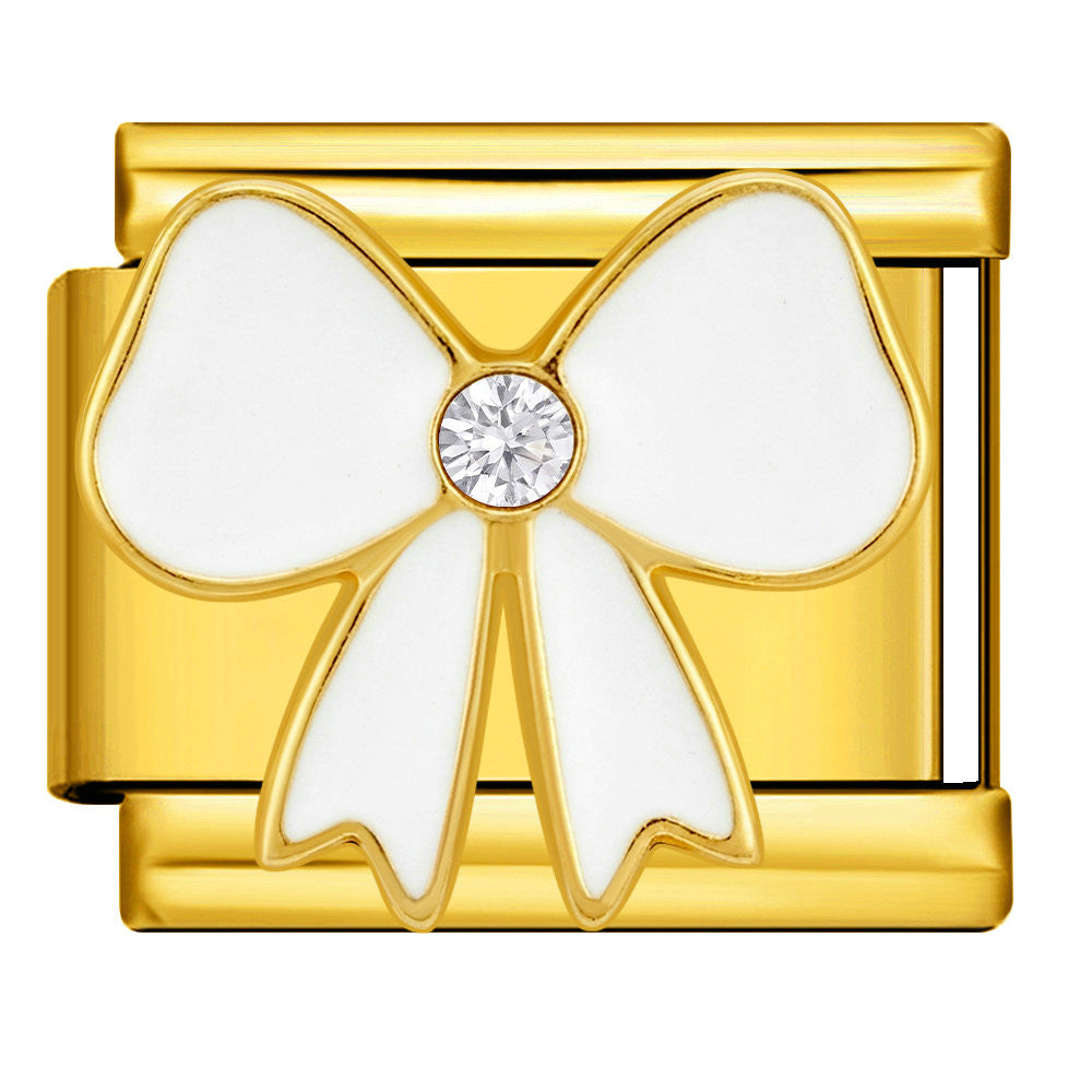 A gold-plated rectangular charm link featuring a white enamel bow design with a clear round crystal at the center, shown on a plain background.